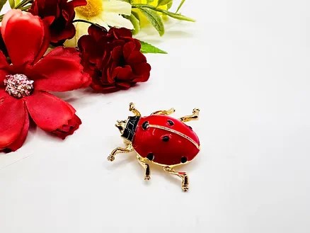 Broche-coccinelle-rouge-et-dorée-en-émail-–-bijou-fantaisie-léger-et-symbolique