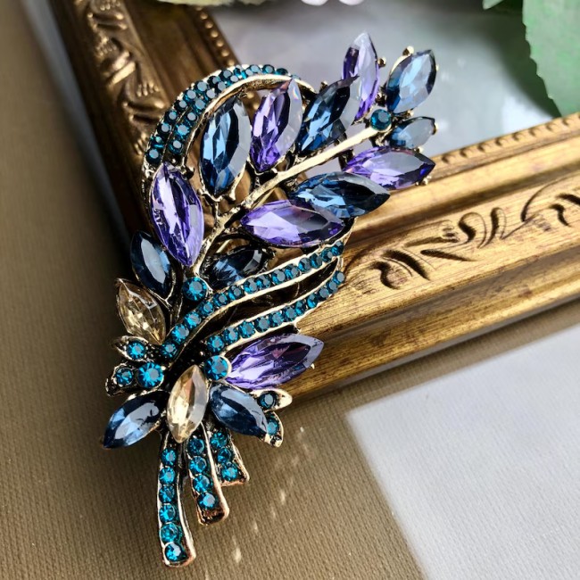 broche feuillage dorée avec strass et cristaux bleus et violets