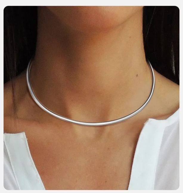 Femme portant un collier torque en acier inoxydable argenté, ras de cou moderne et ajustable
