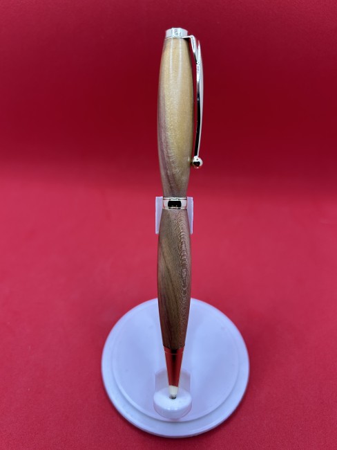 Stylo artisanal en bois de mirabellier – vue détaillée Vue détaillée d'un stylo à bille en bois de mirabellier avec mécanisme métallique et finitions artisanales