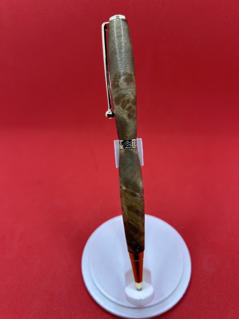 Détail du stylo à bille en bois de loupe de noyer montrant le grain unique du bois et la finition