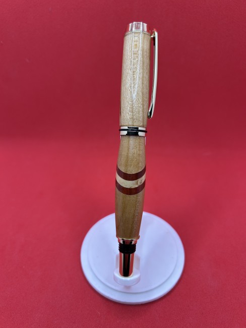 Détail du stylo roller en bois de cerisier, insert padouk et bouleau madré – gros plan