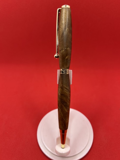 Détail du stylo à bille en bois de loupe de noyer montrant le grain unique du bois et la finition