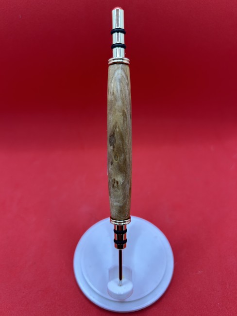 Découd-vite en bois de mirabellier posé avec accessoire d’atelier en arrière-plan