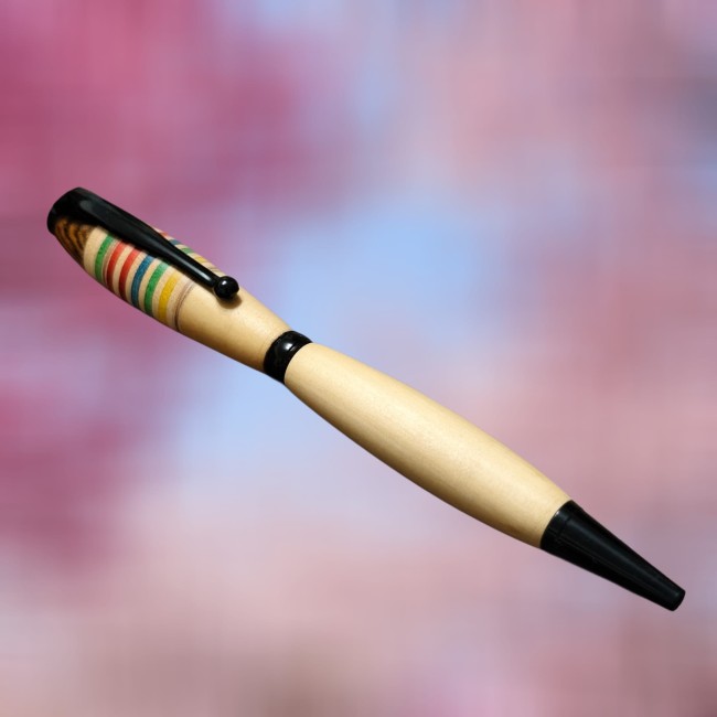 un beau stylo bille en bois vu de face avec un aspect lumineux grâce à son corps en buis, fun avec ses rayures en érable teinté. 