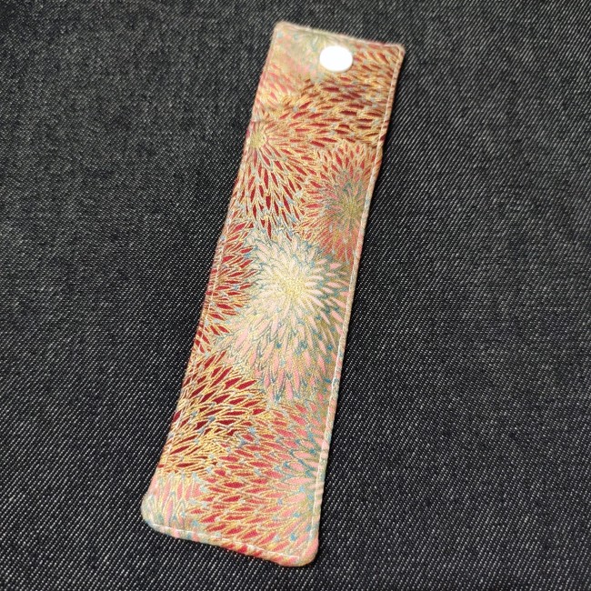 dos d'un étui à stylo en tissu fait main avec beau motif fleuri reflets dorés bordeaux bleu rose - se ferme avec une pression blanche