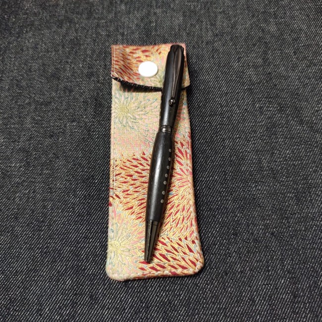 belle petite pochette stylo en tissu à glisser dans son sac à côté d'un stylo en bois en ébène - fleuri doré bordeaux rose bleu