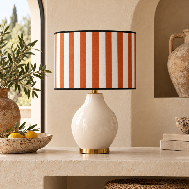 Abat-jour FAUBOURG terracotta à rayures, sur une lampe en céramique ivoire dans un intérieur décoré