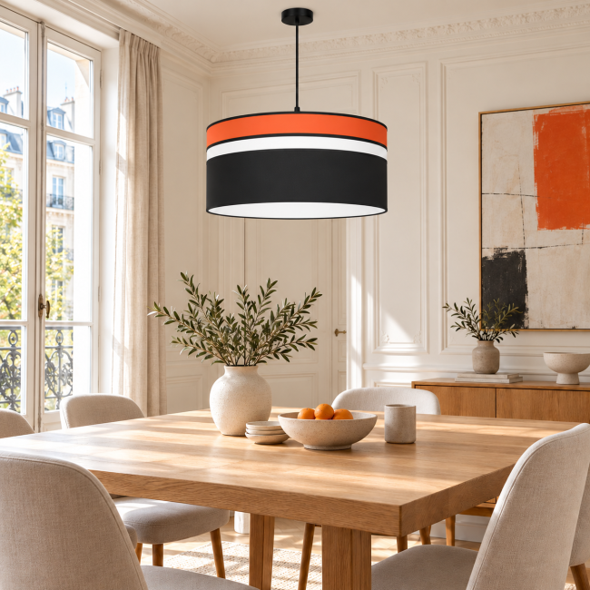 Suspension LUMIO orange au-dessus d’une table dans une salle à manger lumineuse