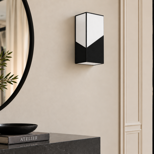 Applique PRISM JAZZ en blanc et noir, éteinte sur un mur à moulures au-dessus d’une console