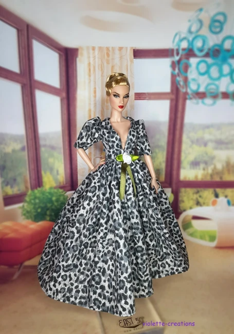 Robe de Bal Léopard Gris pour Poupée | Violette-Creations Robe de bal pour poupée type Barbie en coton imprimé léopard gris et blanc, manches bouffantes, décolleté V, décoration rose blanche et ruban vert olive à la taille, création artisanale par Violette-Creations.