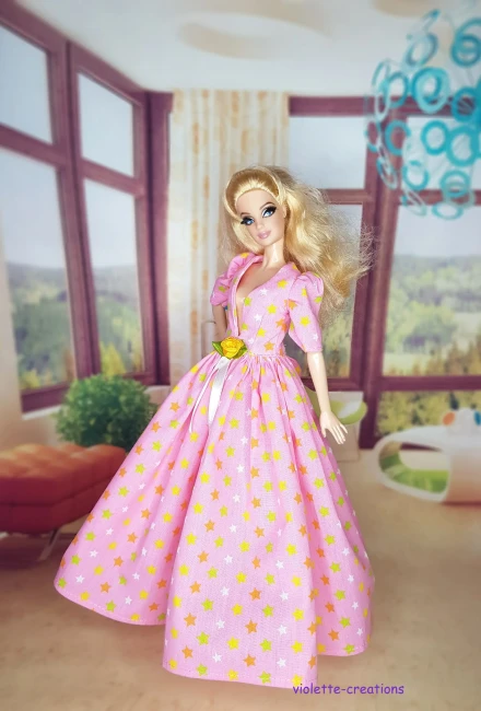 Robe de Bal Rose Clair pour Poupée | Violette-Creations Robe de bal princesse rose clair (pastel) en coton à motifs étoiles multicolores douces avec rose jaune satinée et ruban à la taille, pour poupée mannequin type Barbie, création artisanale par Violette-Creations.