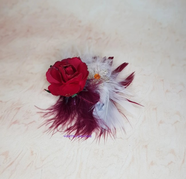 Chapeau bibi rouge pour poupée type barbie avec rose à paillettes, plumes bordeaux et blanches, et ornement doré.