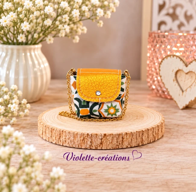 Sac à main miniature en coton imprimé orange, vert et blanc, avec rabat en simili cuir orange texturé, strass et chaînette dorée pour poupée mannequin 29 cm.
