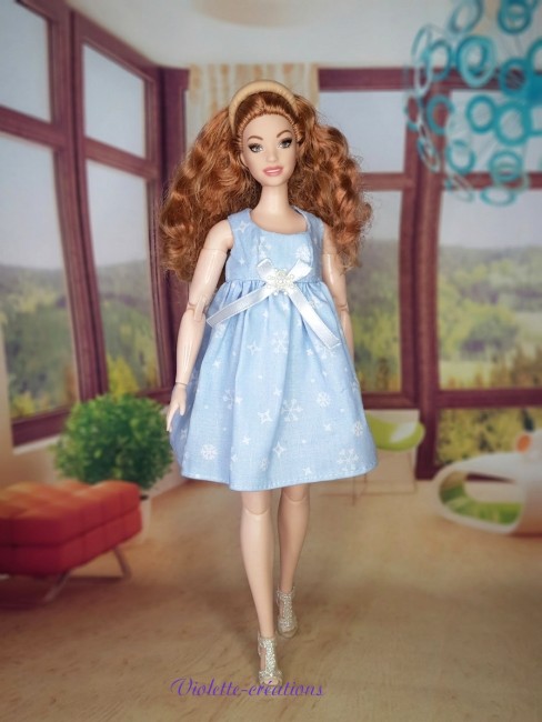 robe-bleue-coton-flocons-barbie-curvy. (2) Robe en coton bleu ciel à motifs flocons de neige avec nœud en satin pour poupée Barbie Curvy, création artisanale Violette-Créations.