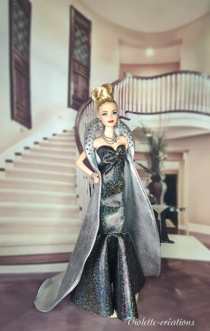 Poupée barbie portant une robe de soirée longue à paillettes avec cape argentée, dans un décor de grand escalier luxueux