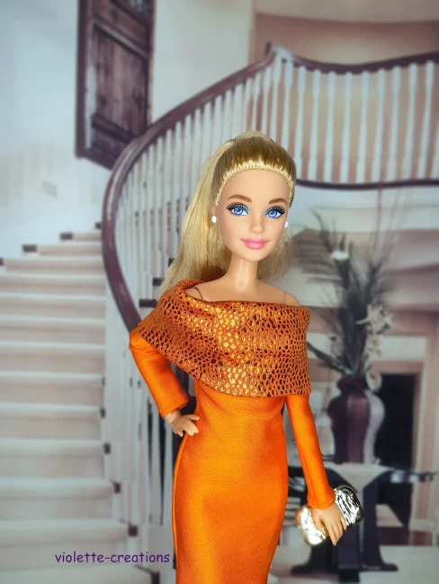 Gros plan sur le bustier orange texturé d'une robe de fête pour poupée de collection