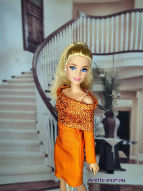 Gros plan sur le bustier orange texturé d'une robe de fête pour poupée de collection