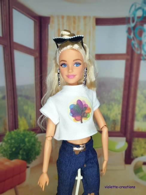 Tenue complète pour poupée Barbie: pantalon pattes d’eph, t-shirt blanc, manteau fausse fourrure et maillot de bain doré.