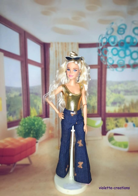 Tenue complète pour poupée Barbie: pantalon pattes d’eph, t-shirt blanc, manteau fausse fourrure et maillot de bain doré.