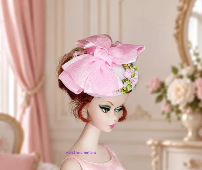 Bibi Nœud Rose et Fleurs pour Poupée type Barbie | violette-creations Chapeau bibi blanc pour poupée type barbie avec grand nœud rose en satin et broderies florales.