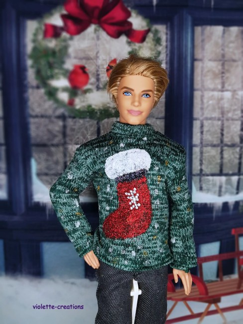 Pull de Noël vert pour Ken – Chaussette rouge scintillante – Violette Créations Ken portant un pull de Noël vert avec une chaussette rouge scintillante.
