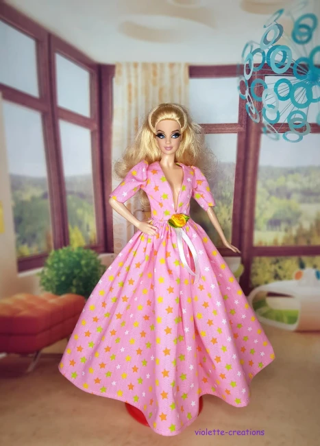 Robe de Bal Rose Clair pour Poupée | Violette-Creations Robe de bal princesse rose clair (pastel) en coton à motifs étoiles multicolores douces avec rose jaune satinée et ruban à la taille, pour poupée mannequin type Barbie, création artisanale par Violette-Creations.