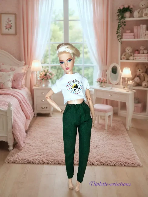 Pyjama-en-Coton-Vert-Forêt-et-Crop-top-pour-Poupee-Mannequin-type-barbie Pyjama en coton pour poupée type Barbie composé d'un t-shirt blanc et d'un pantalon vert foncé dans une chambre miniature