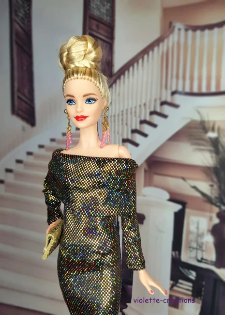 Détail du bustier et de l'encolure bateau d'une robe de fête pour poupée, tissu scintillant or sur fond noir