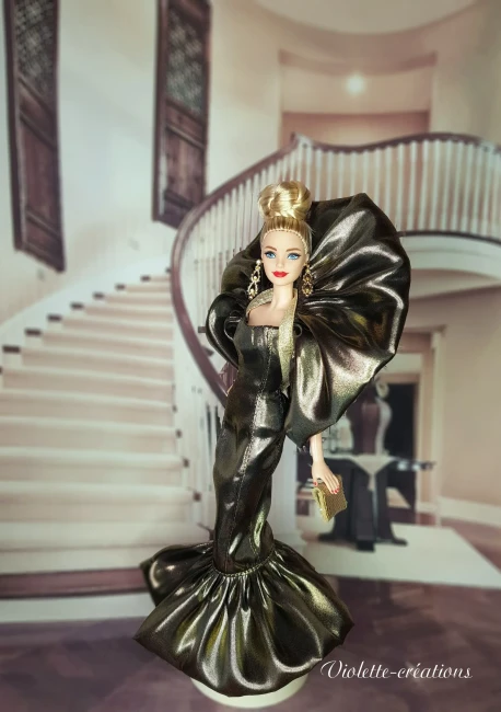 Poupée type Barbie portant une robe de soirée glamour en satin lamé or style haute couture