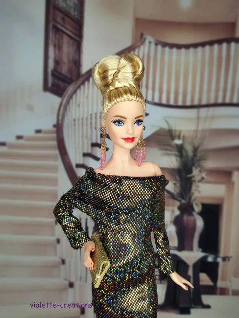 Détail du bustier et de l'encolure bateau d'une robe de fête pour poupée, tissu scintillant or sur fond noir