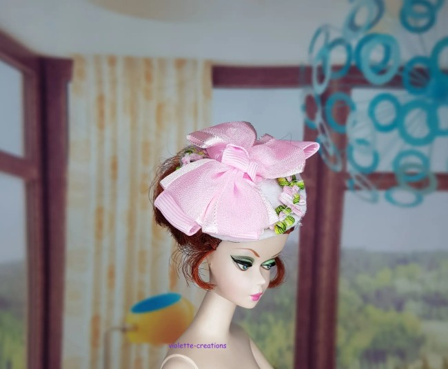 Chapeau bibi blanc pour poupée type barbie avec grand nœud rose en satin et broderies florales.
