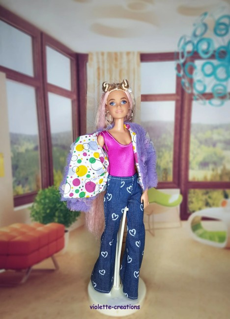 Tenue complĂšte vintage pour poupĂ©e Barbie â Jean Ă cĆurs, blouson papillons, maillot fushia PoupĂ©e Barbie portant un jean bleu Ă cĆurs, un maillot rose fushia, un blouson violet dĂ©corĂ© de papillons et un t-shirt Ă motif sous le blouson.