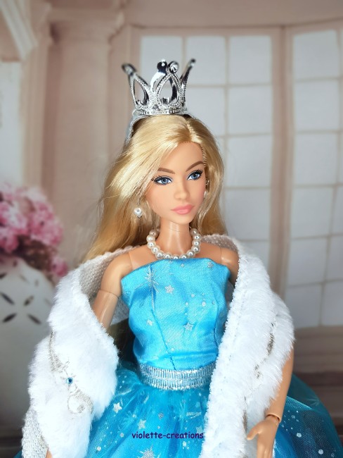 Robe de Princesse Bleu Étoilé pour Poupée barbie – Tenue Scintillante Poupée Barbie portant une robe bleu clair scintillante avec petites étoiles argentées, étole blanche, couronne et bijoux.
