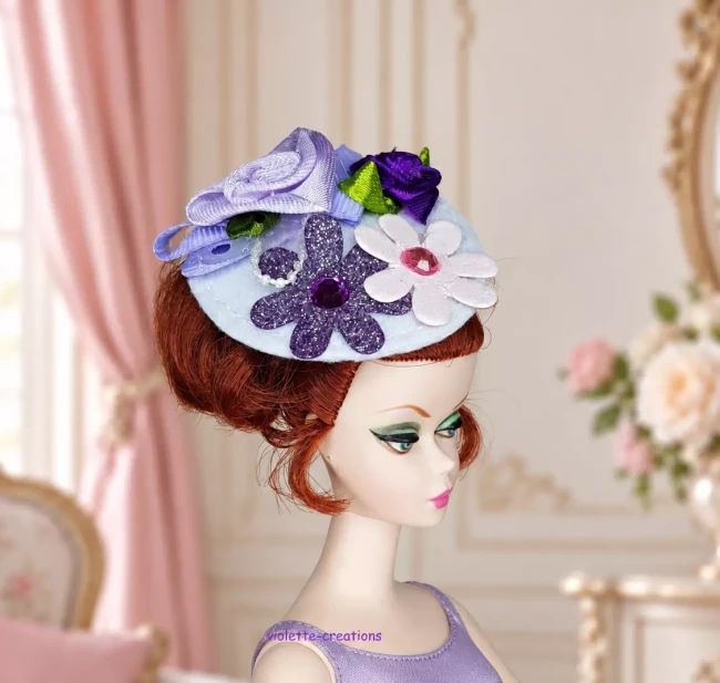 Bibi Fleurs et Perles pour Poupée type Barbie | violette-creations Chapeau bibi lilas pour poupée type barbie avec roses en ruban, fleurs pailletées et perles blanches.