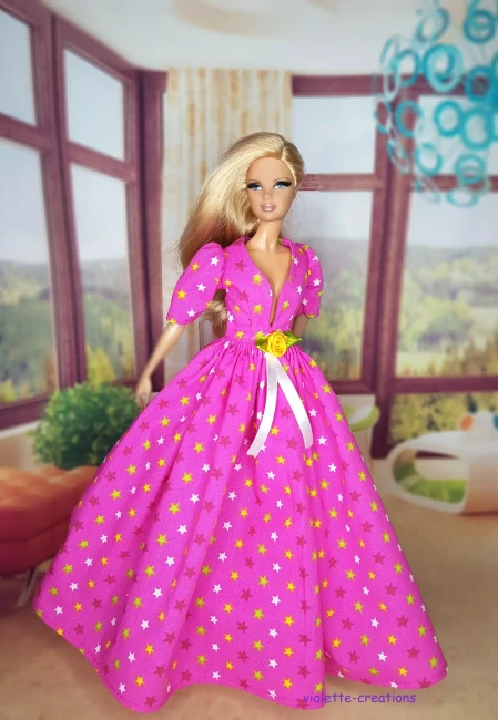 Robe de Bal Rose Étoilée en Coton pour Poupée | Violette-Creations Robe de bal rose en coton à motifs étoiles avec rose jaune à la taille pour poupée mannequin type Barbie, création artisanale par Violette-Creations.