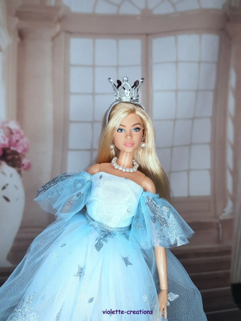 Robe de Princesse Bleu Givré pour Poupée Barbie – Tenue Féérique Poupée barbie portant une robe de princesse bleu clair avec flocons argentés, couronne et bijoux.