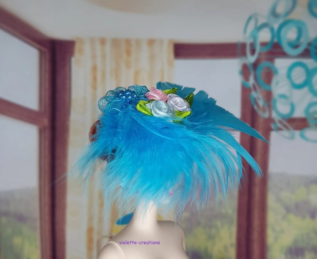 Bibi bleu turquoise pour poupée avec panache de plumes et bouquet de mini roses en ruban.