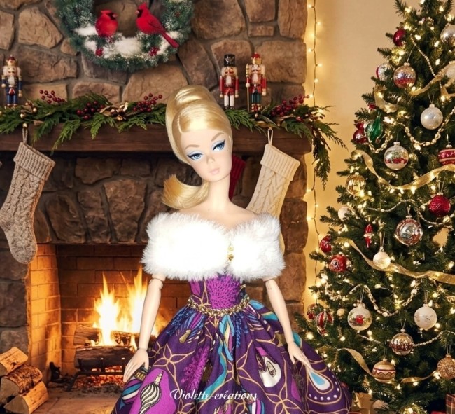 Poupée Barbie avec robe violette de Noël à motifs de boules de Noel, bordée de fourrure blanche