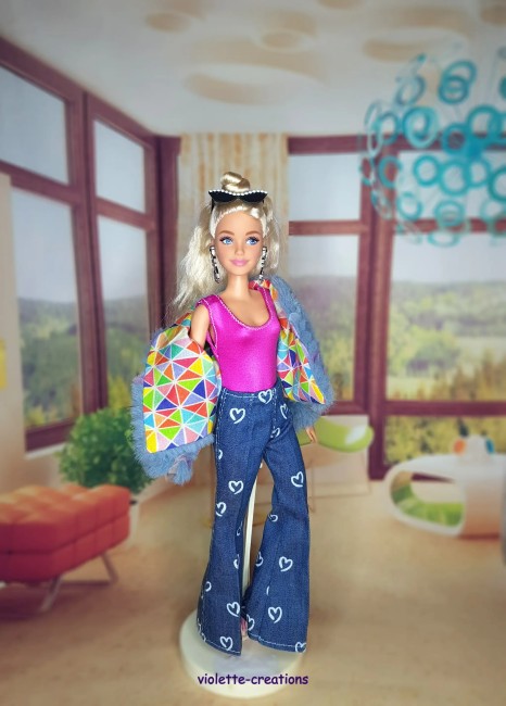 Tenue complĂšte vintage pour poupĂ©e Barbie â Jean Ă cĆurs, blouson papillons, maillot fushia PoupĂ©e Barbie portant un jean bleu Ă cĆurs, un maillot rose fushia, un blouson violet dĂ©corĂ© de papillons et un t-shirt Ă motif sous le blouson.