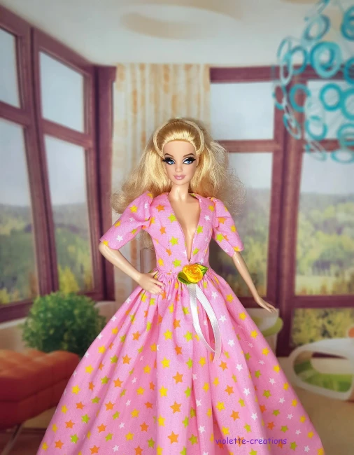 Robe de Bal Rose Clair pour Poupée | Violette-Creations Robe de bal princesse rose clair (pastel) en coton à motifs étoiles multicolores douces avec rose jaune satinée et ruban à la taille, pour poupée mannequin type Barbie, création artisanale par Violette-Creations.