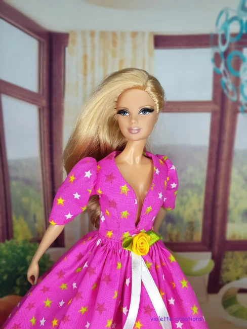 Robe de Bal Rose Étoilée en Coton pour Poupée | Violette-Creations Robe de bal rose en coton à motifs étoiles avec rose jaune à la taille pour poupée mannequin type Barbie, création artisanale par Violette-Creations.