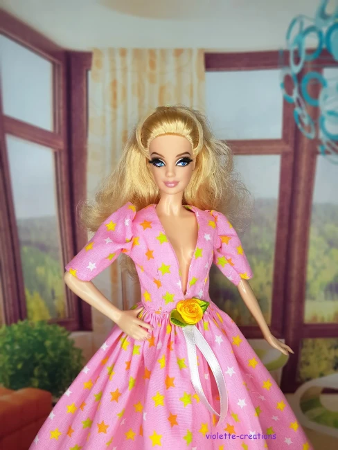 Robe de Bal Rose Clair pour Poupée | Violette-Creations Robe de bal princesse rose clair (pastel) en coton à motifs étoiles multicolores douces avec rose jaune satinée et ruban à la taille, pour poupée mannequin type Barbie, création artisanale par Violette-Creations.