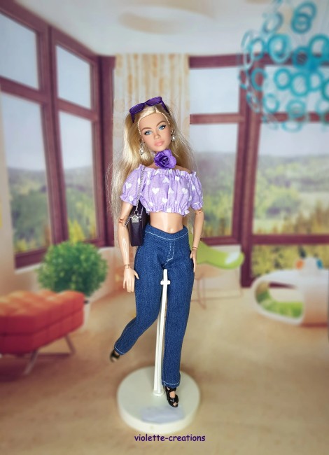 Tenue artisanale pour poupée mannequin 29 cm type Barbie – top lilas à cœurs, jean moderne et collier fleuri assorti.