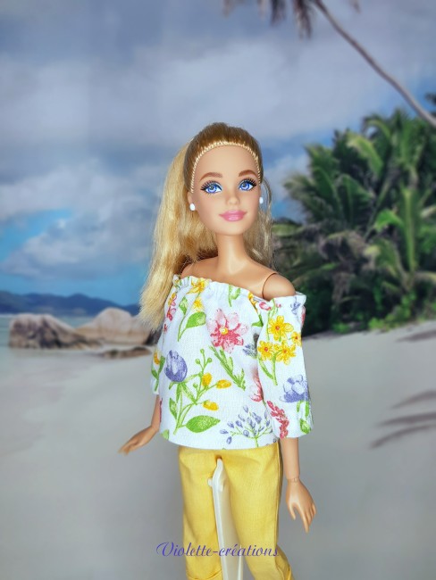 Poupée Barbie en tenue estivale fleurie et pantalon jaune Poupée barbie avec une tenue décontractée estivale composée d'un haut fleuri et d'un pantalon jaune.
