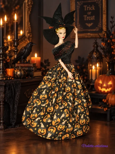 Déguisement Halloween avec robe en coton, motifs de citrouilles, chapeau en feutrine noir avec chauve-souris pailletée, étole en fausse fourrure noir et balai de sorcière miniature.