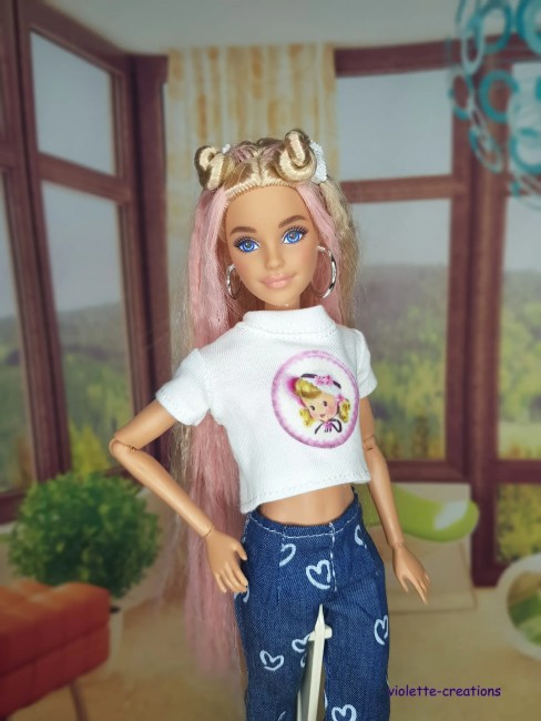 Tenue complĂšte vintage pour poupĂ©e Barbie â Jean Ă cĆurs, blouson papillons, maillot fushia PoupĂ©e Barbie portant un jean bleu Ă cĆurs, un maillot rose fushia, un blouson violet dĂ©corĂ© de papillons et un t-shirt Ă motif sous le blouson.