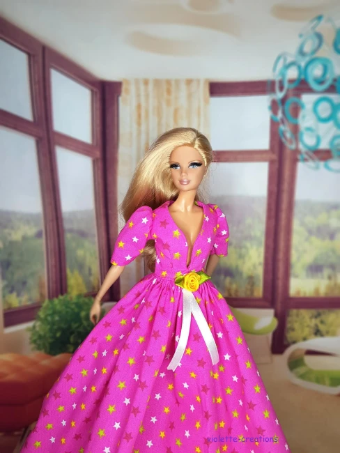 Robe de Bal Rose Étoilée en Coton pour Poupée | Violette-Creations Robe de bal rose en coton à motifs étoiles avec rose jaune à la taille pour poupée mannequin type Barbie, création artisanale par Violette-Creations.