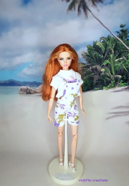 Salopette Bucolique Lavande & T-shirt Blanc pour Poupée Barbie - Violette-Créations Poupée Barbie rousse articulée portant une salopette short à motifs lavande et un crop-top blanc assorti, création artisanale Violette-Créations.