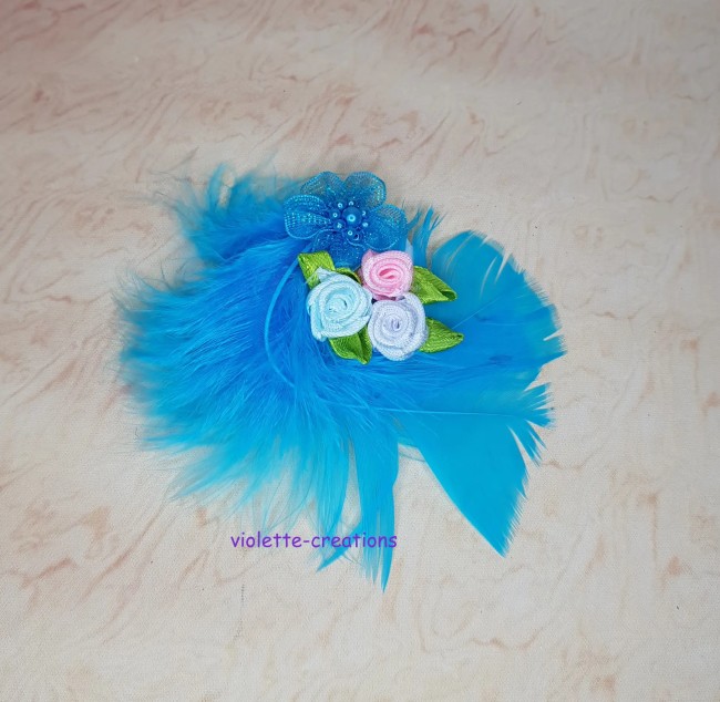 Bibi bleu turquoise pour poupée avec panache de plumes et bouquet de mini roses en ruban.